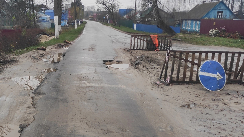 Житель посёлка Локоть просит заделать дыру на дороге и убрать бесполезный знак объезда